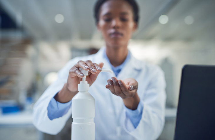lab technician sanitising hands