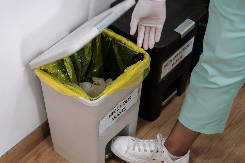 A Clinician discarding infectious waste into the yellow colour coded bag for infectious waste streams