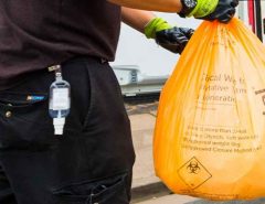 Initial Medical technician holding clinical wasted disposal bag