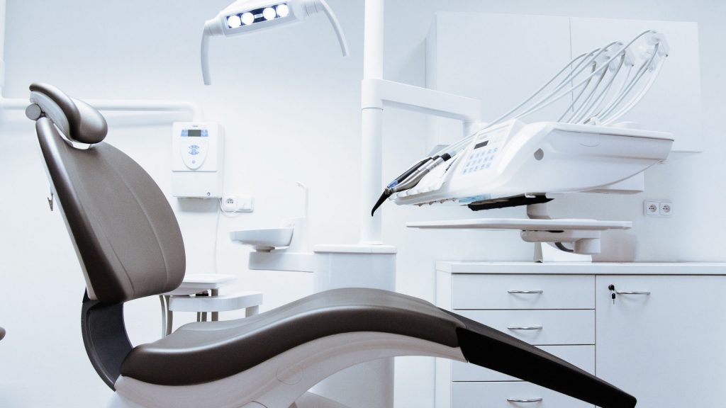 Modern dental chair in a bright, clean clinic room.