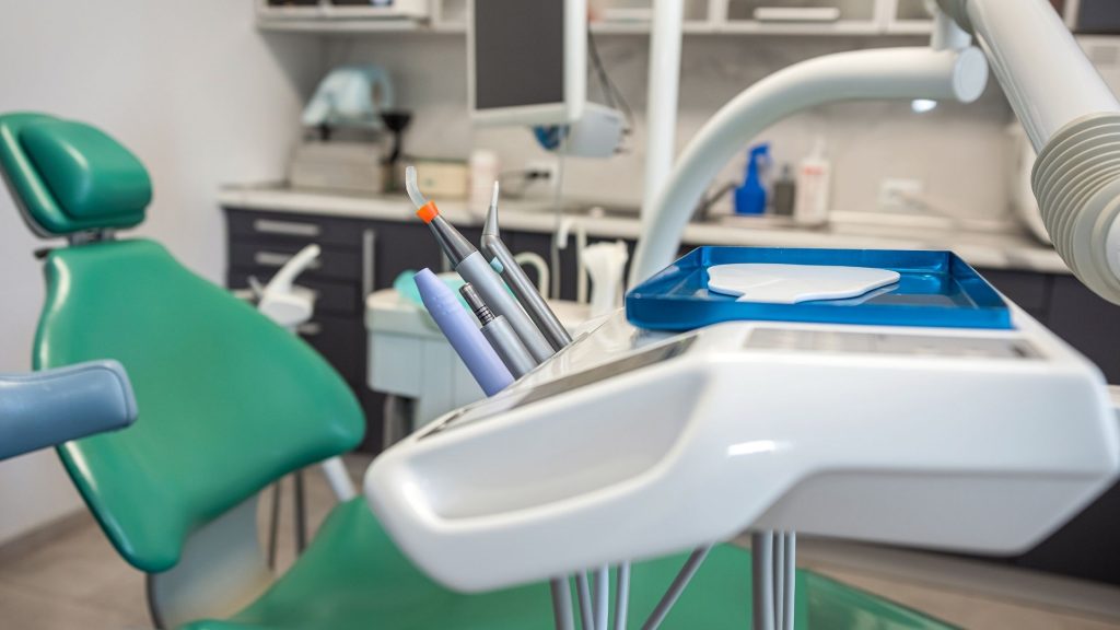 Close-up of a modern dental treatment chair and equipment tray in a clean dental surgery.